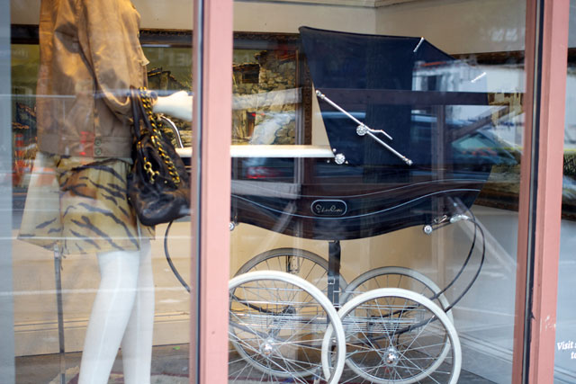 An antique-styled baby carriage in the Housing Works display window