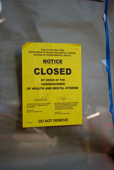 The health department closure notice on the window of the River Side Deli