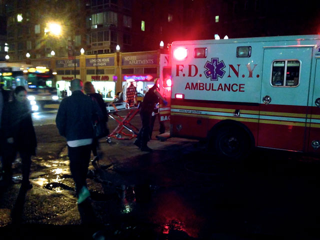 Paramedics carrying the woman into an ambulance