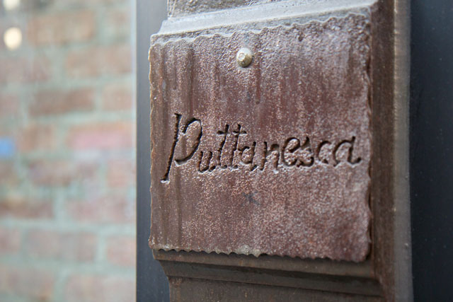 An engraving of the restaurant's name on an exterior beam