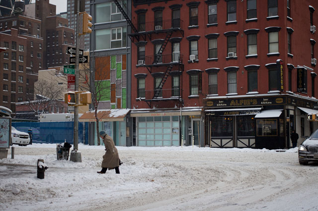 A man walking through snow on 9th Ave