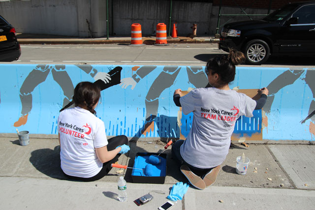 Volunteers painting the art piece at the pedestrian plaza