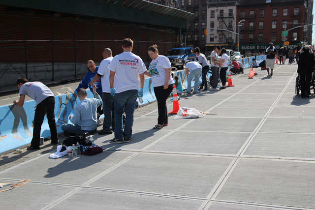 Volunteers painting the art piece at the pedestrian plaza