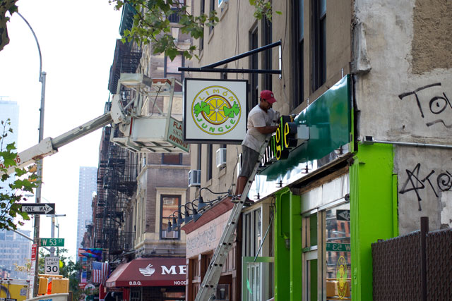 Workers installing the new, wider Limón Jungle signage